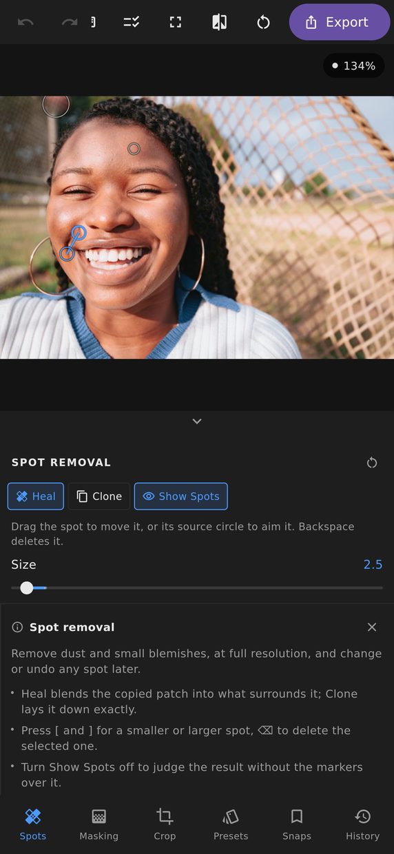 The Spot removal panel open on a phone, with three spot markers on a portrait and the selected one joined to the place its patch was copied from